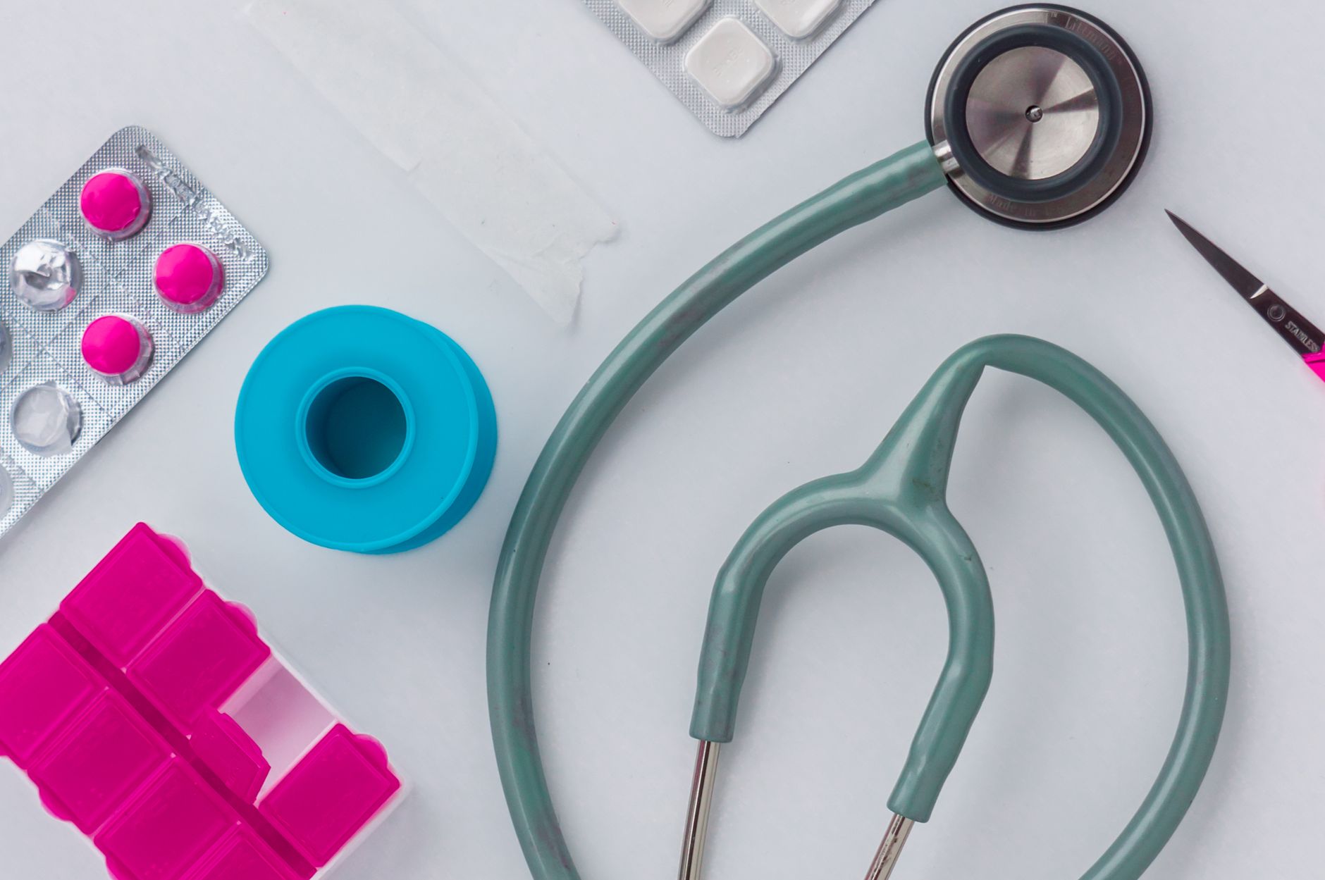 Overhead shot of medical supplies including stethoscope, pills, and scissors. — Online Clinics Helping Men Restore Testostero